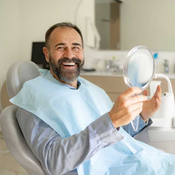 Happy male patient smiling after treatment at the dentist