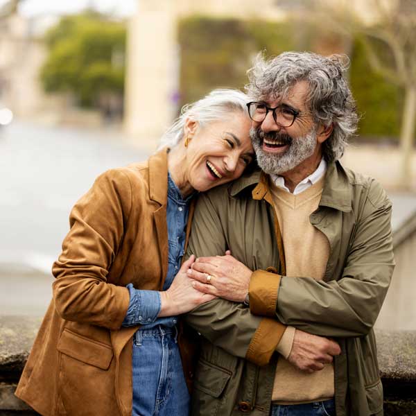 senior couple hugging and laughing outside